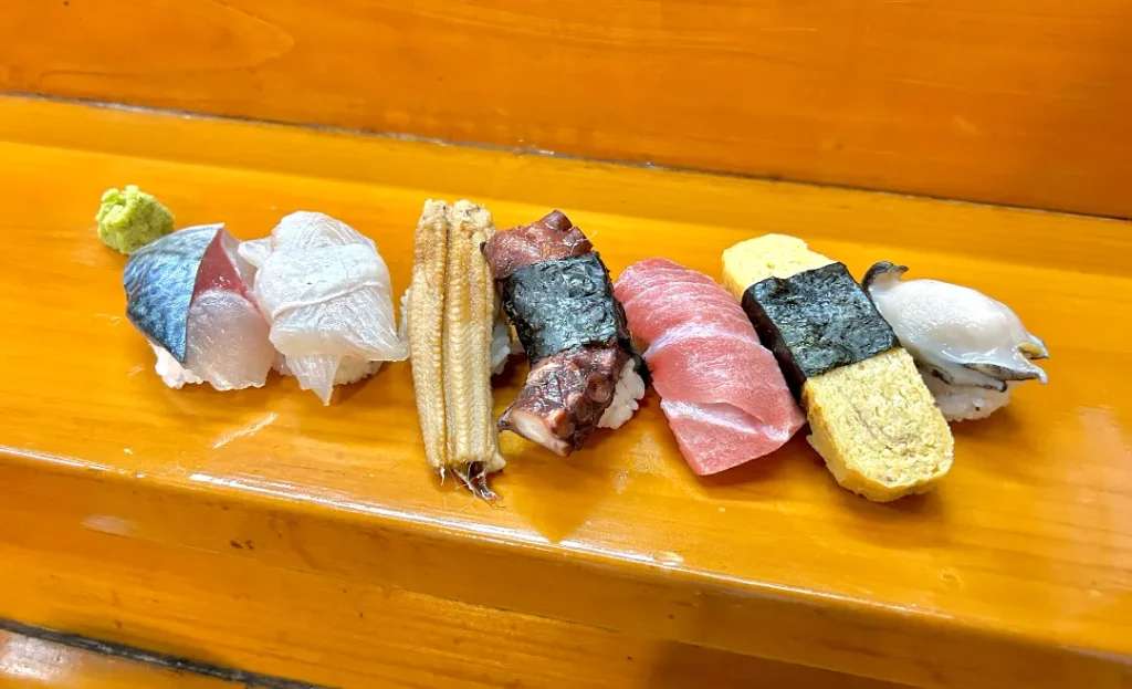 Những miếng sushi với đủ các loại từ hải sản đến thịt và trứng được bày trực tiếp trên bàn, đây là một phong cách sushi truyền thống, chú trọng vào hương vị thức ăn hơn hình thức trang trí