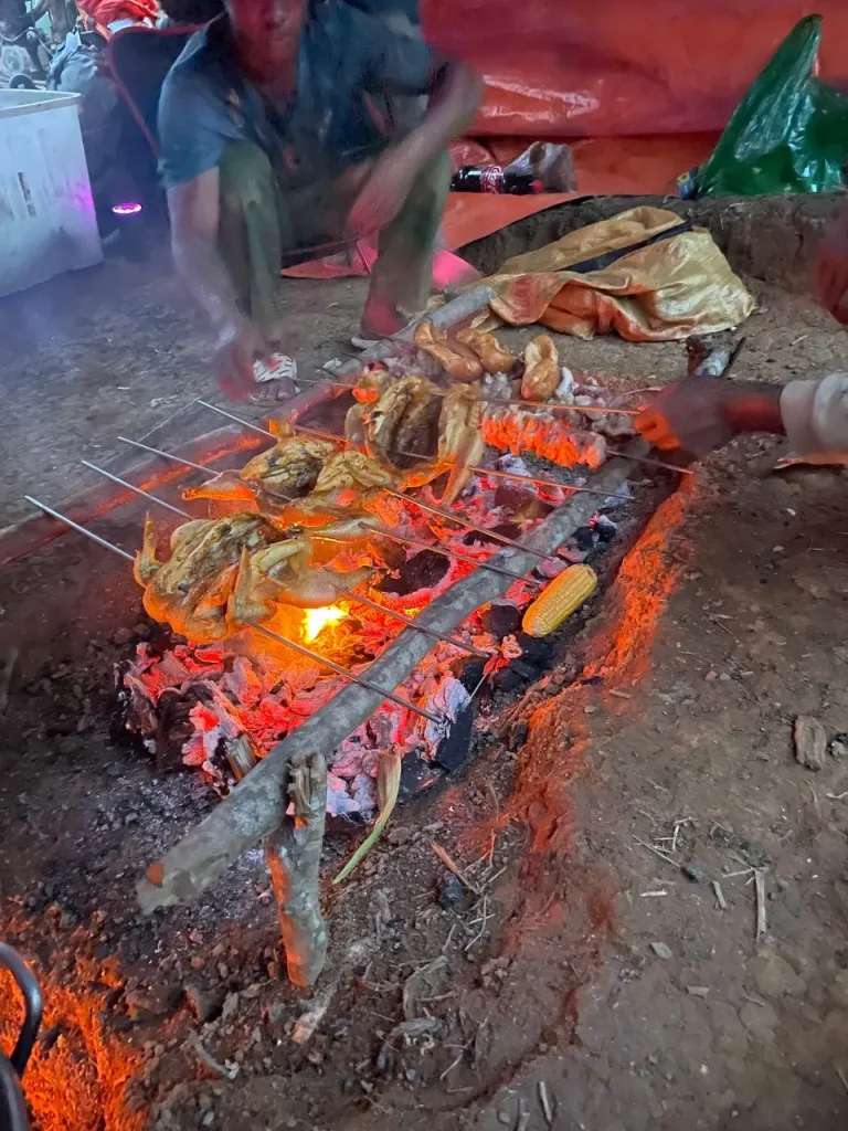 Các bạn guide người Churu đang nướng gà, lợn, ngô và khoai cho bữa tối trên bãi trại 